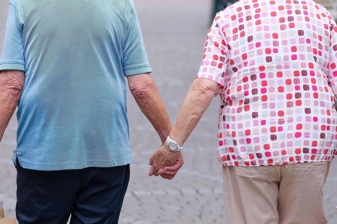 älteres Ehepaar geht Hand in Hand spazieren