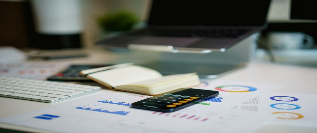 Handy und Unterlagen zur Finanzplanung auf einem Tisch